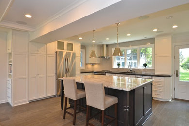 Transitional porcelain tile eat-in kitchen photo in DC Metro with a single-bowl sink, flat-panel cabinets, white cabinets, quartz countertops, glass tile backsplash, stainless steel appliances and an island