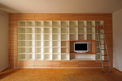 Mittelgroße Bibliothek im Loft-Stil mit hellem Holzboden und TV-Wand in Sonstige