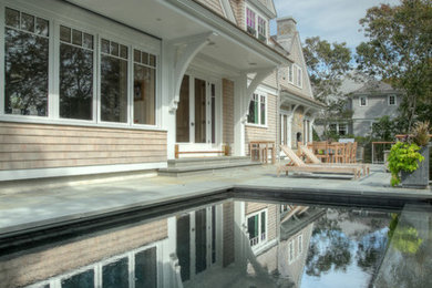 Pool - small backyard rectangular infinity pool idea in Boston