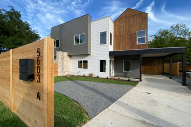 Example of a minimalist two-story mixed siding exterior home design in Austin with a mixed material roof