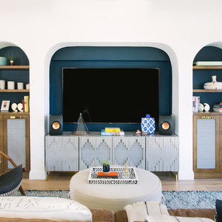 Offenes Mediterranes Wohnzimmer mit bunten Wänden, hellem Holzboden und Multimediawand in Los Angeles