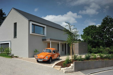 Mittelgroßes, Zweistöckiges Modernes Einfamilienhaus mit Putzfassade, grauer Fassadenfarbe, Satteldach und Ziegeldach in Sonstige