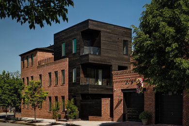 Photo of a large modern three-storey brown apartment exterior in Baltimore with mixed siding, a flat roof and a shingle roof.