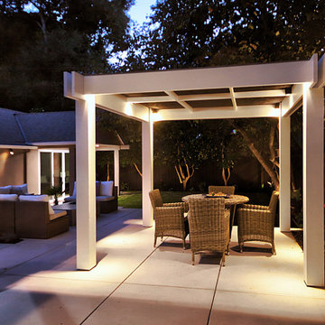 Serene Nighttime Backyard with Pergola and Uplighted Trees