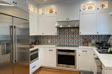 Idéer för att renovera ett mellanstort vit vitt kök, med en undermonterad diskho, skåp i shakerstil, vita skåp, bänkskiva i kvarts, flerfärgad stänkskydd, stänkskydd i keramik, rostfria vitvaror, ljust trägolv, en halv köksö och brunt golv