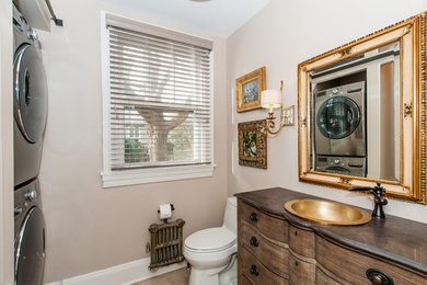 Inspiration for a mid-sized transitional powder room in Baltimore with furniture-like cabinets, dark wood cabinets, beige walls, ceramic floors, a drop-in sink, granite benchtops and a one-piece toilet.
