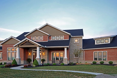 Large arts and crafts red two-story mixed siding exterior home photo in Other with a shingle roof