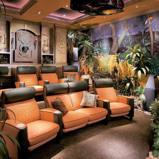 Inspiration for a mid-sized tropical enclosed carpeted and brown floor home theater remodel in Atlanta with multicolored walls and a projector screen