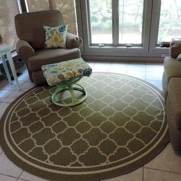 A Cozy Sunroom Makeover- A round rug breaks up all the hard angles in the room.
