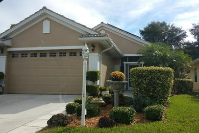Inspiration for a mid-sized timeless brown one-story stucco house exterior remodel in Tampa