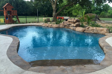 Inspiration for a mid-sized transitional backyard stamped concrete and custom-shaped lap pool fountain remodel in Houston