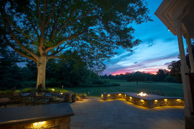 Mid-sized trendy backyard stone patio photo in New York with a fire pit and a gazebo