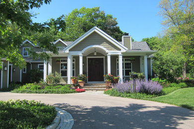 Example of a large farmhouse green two-story vinyl exterior home design in Milwaukee with a shingle roof