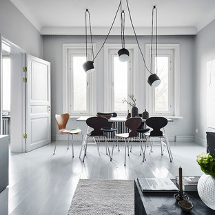 Inredning av en nordisk matplats med öppen planlösning, med vita väggar och målat trägolv