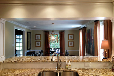 Eat-in kitchen - mid-sized transitional u-shaped medium tone wood floor eat-in kitchen idea in New Orleans with a double-bowl sink, white cabinets, granite countertops, white backsplash, ceramic backsplash, stainless steel appliances and an island