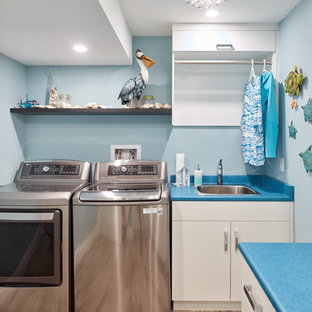 This is an example of a medium sized traditional l-shaped separated utility room in Vancouver with a built-in sink, flat-panel cabinets, white cabinets, laminate countertops, blue walls, medium hardwood flooring, a side by side washer and dryer, brown floors and blue worktops.