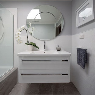 Immagine di una piccola stanza da bagno con doccia moderna con nessun'anta, ante bianche, vasca da incasso, vasca/doccia, piastrelle grigie, piastrelle in ceramica, pareti bianche, pavimento in gres porcellanato, lavabo integrato e top in saponaria