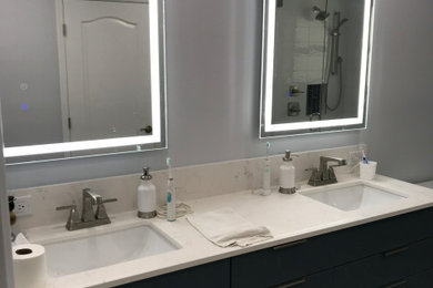 Diseño de cuarto de baño principal, doble y de pie minimalista de tamaño medio con armarios con paneles lisos, puertas de armario azules, baldosas y/o azulejos blancos, encimera de cuarcita y encimeras blancas
