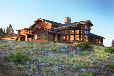 Huge rustic two-story wood exterior home idea in Other with a shingle roof