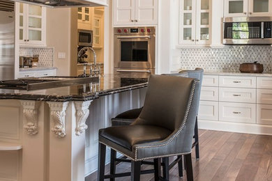 Inspiration for a large transitional u-shaped medium tone wood floor and brown floor open concept kitchen remodel in Phoenix with an undermount sink, shaker cabinets, white cabinets, marble countertops, multicolored backsplash, stone tile backsplash, stainless steel appliances and an island