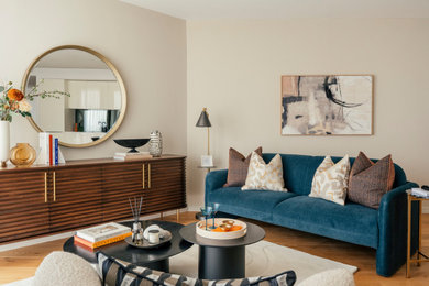 Contemporary living room in London with beige walls, medium hardwood flooring and brown floors.