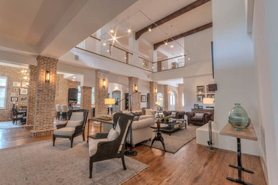 Huge transitional open concept medium tone wood floor living room photo in Atlanta with white walls
