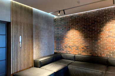 Свежая идея для дизайна: изолированная гостиная комната среднего размера в современном стиле с зелеными стенами, полом из ламината, телевизором на стене, коричневым полом, с книжными шкафами и полками, кирпичными стенами и акцентной стеной без камина - отличное фото интерьера