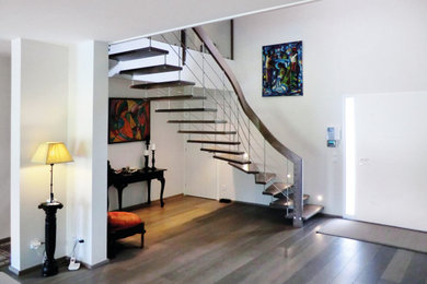 Aménagement d'un escalier flottant contemporain avec des marches en bois et un garde-corps en métal.