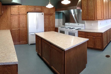 Enclosed kitchen - large craftsman l-shaped concrete floor and blue floor enclosed kitchen idea in Other with a double-bowl sink, shaker cabinets, medium tone wood cabinets, laminate countertops, white backsplash, white appliances and an island