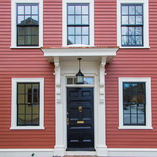 ボストンの中サイズの片開きドアトラディショナルスタイルのおしゃれな玄関 (黒いドア、赤い壁) の写真