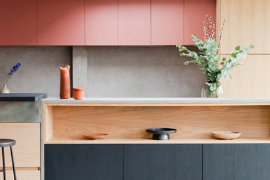 Photo of a contemporary kitchen in Other with flat-panel cabinets, light wood cabinets, grey splashback, with island, grey floor and grey benchtop.
