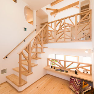 他の地域の木のコンテンポラリースタイルのおしゃれな階段 (フローリングの蹴込み板、木材の手すり) の写真