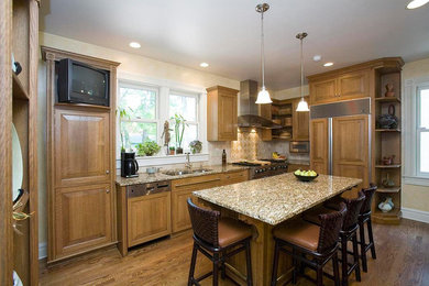 Mid-sized elegant l-shaped medium tone wood floor and brown floor eat-in kitchen photo in Chicago with light wood cabinets, granite countertops, beige backsplash, stainless steel appliances, an island, a double-bowl sink, raised-panel cabinets and ceramic backsplash