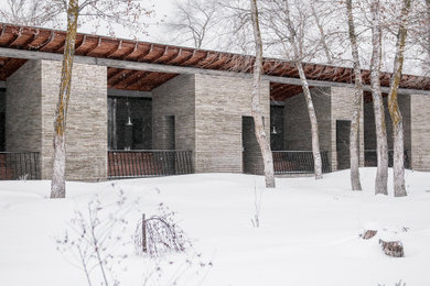 Идея дизайна: одноэтажный, серый дом среднего размера в современном стиле с облицовкой из камня, плоской крышей и крышей из смешанных материалов