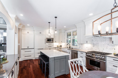 Design ideas for a large transitional eat-in kitchen in Charlotte with a farmhouse sink, shaker cabinets, white cabinets, quartz benchtops, grey splashback, stainless steel appliances, medium hardwood floors, with island and brown floor.