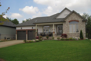 Example of a mid-sized classic beige one-story brick house exterior design in Toronto with a hip roof and a shingle roof