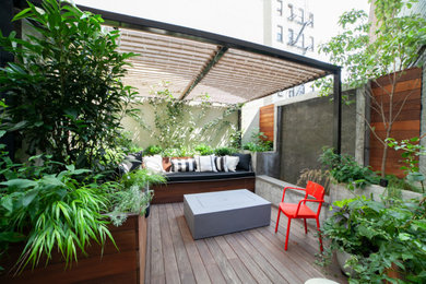 Deck - mid-sized modern backyard ground level mixed material railing deck idea in New York with a fire pit and a pergola