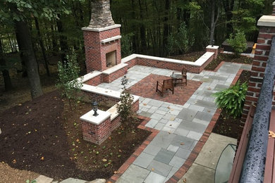 Mid-sized elegant backyard brick patio photo in Other with a fire pit and no cover