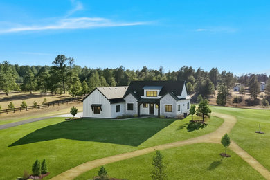 Inspiration for a mid-sized transitional gray one-story stucco and board and batten house exterior remodel in Denver with a black roof
