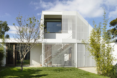 Design ideas for a small contemporary two-storey white exterior in Melbourne with wood siding.