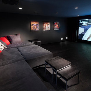 This is an example of a large modern enclosed home cinema in Tel Aviv with black walls, dark hardwood flooring, a built-in media unit and black floors.