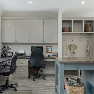 This is an example of a large coastal u-shaped utility room in Minneapolis with a submerged sink, flat-panel cabinets, white cabinets, engineered stone countertops, grey walls, laminate floors, a side by side washer and dryer, brown floors and grey worktops.
