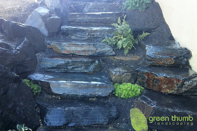 Photo of a mid-sized rustic partial sun side yard stone retaining wall landscape in Edmonton for summer.