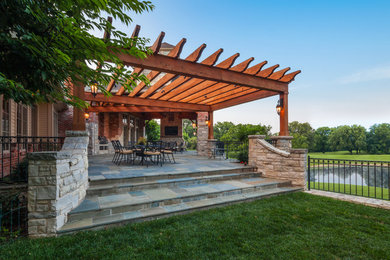 Large mountain style tile back porch photo in St Louis with a pergola