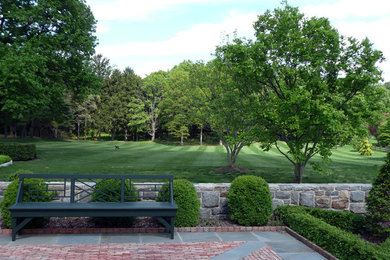 Photo of a huge traditional partial sun courtyard brick landscaping in New York for summer.