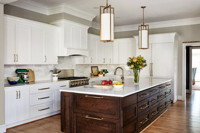 Example of a large transitional l-shaped kitchen design in DC Metro with white cabinets, an island and white countertops