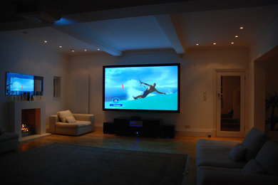 Photo of a contemporary home cinema in Hertfordshire with a projector screen.