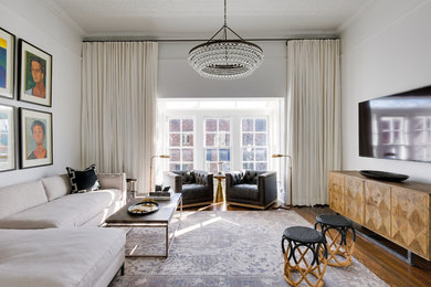 Example of a large transitional enclosed medium tone wood floor and brown floor family room design in Nashville with white walls, no fireplace and a wall-mounted tv