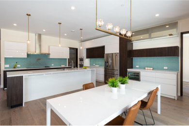 ワシントンD.C.にある高級な巨大なモダンスタイルのおしゃれなダイニングキッチン (アンダーカウンターシンク、フラットパネル扉のキャビネット、白いキャビネット、珪岩カウンター、青いキッチンパネル、セラミックタイルのキッチンパネル、シルバーの調理設備、クッションフロア、茶色い床、白いキッチンカウンター) の写真