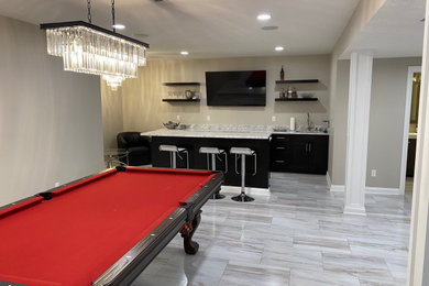 Large minimalist look-out laminate floor and gray floor basement photo in Columbus with a bar and gray walls
